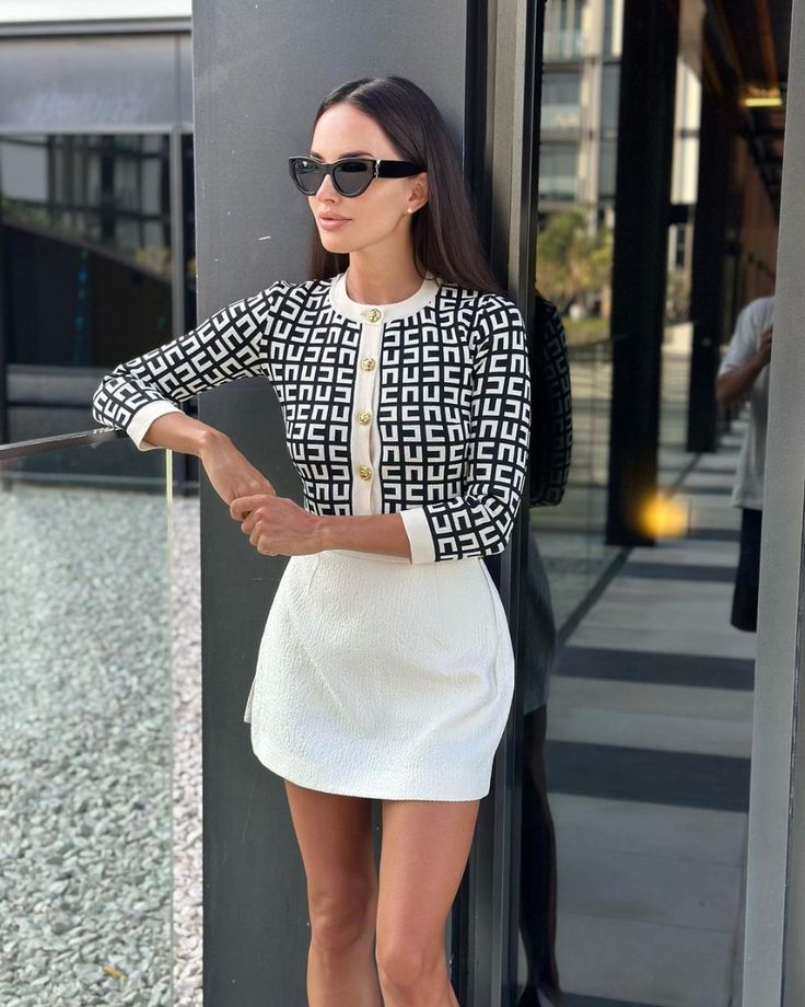 white patterned cardigan paired with a white textured mini skirt